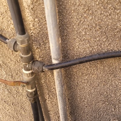 צינורות מחוברים לקיר עם ברז מתכת