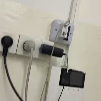 שקעים וכבלים על קיר לבן