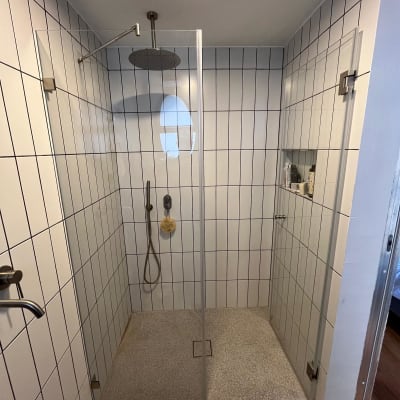 מקלחת עם ראש גשם, קירות אריחים ומדף מוצרים