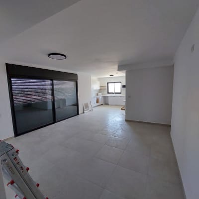 סולם מתכת מתקפל בחדר ריק עם חלון גדול