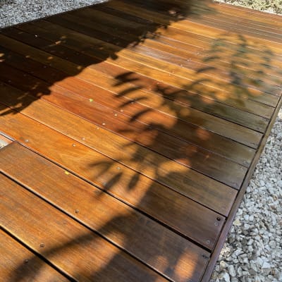 דק עץ מבריק עם צללים בגינה