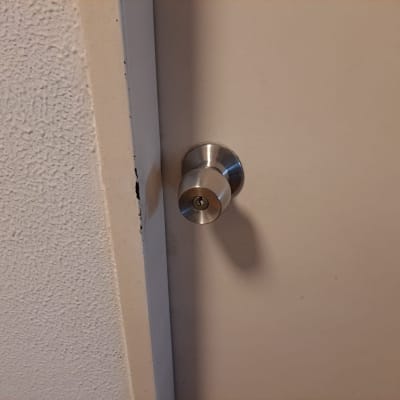 ידית דלת מתכתית על דלת לבנה