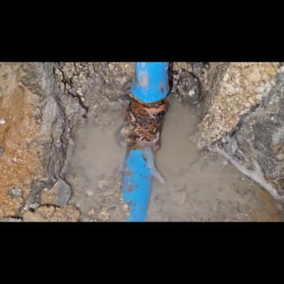 תמונה של צינור מים כחול עם נזילה באדמה