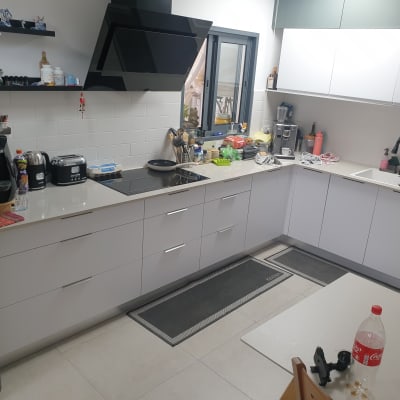 מטבח מודרני עם מכשירי חשמל וכלי בישול על השיש