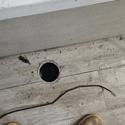 ניקוז מים על רצפה עם כלי עבודה ומגפיים