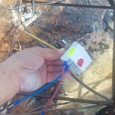 יד מחזיקה חוטי חשמל מחוברים למכשיר קטן