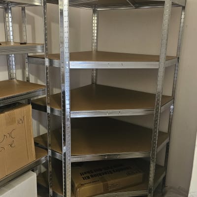 מדפי מתכת מותקנים בפינה, קופסאות קרטון על הרצפה