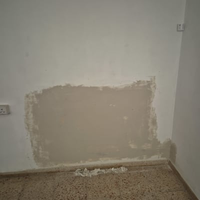 תיקון קיר עם טיח על רצפת אריחים