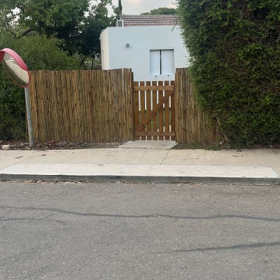 גדר עץ ליד בית עם צמחייה מסביב