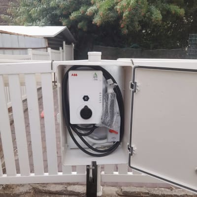 עמדת טעינה חשמלית עם כבלים בתוך ארון פתוח