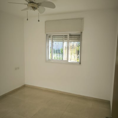 חדר ריק עם מאוורר תקרה וחלון
