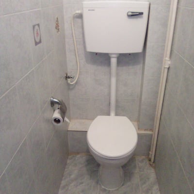 אסלה עם מיכל הדחה וצינור מים