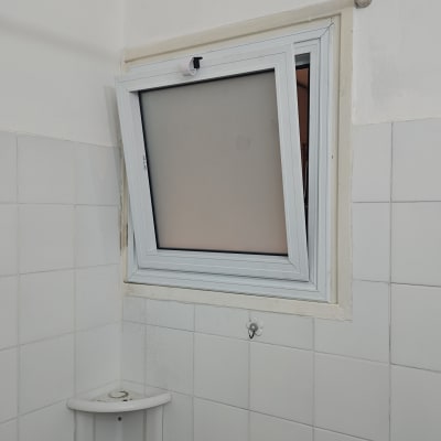 חלון אלומיניום פתוח בחדר אמבטיה עם אריחים לבנים