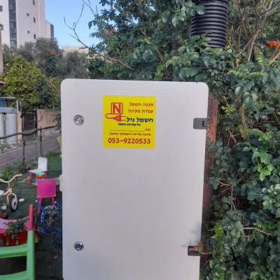 ארון חשמל עם מדבקה צהובה ופרטי חשמלאי