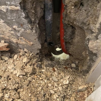 צינורות חשופים בקיר עם חצץ מסביב