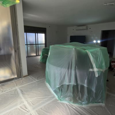 כיסוי והגנה על רהיטים ורצפה בניילון לפני צביעת דירה מרוהטת