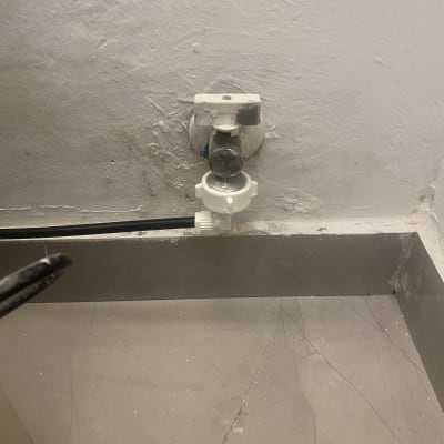 ברז מים עם חיבור צינור על קיר לבן