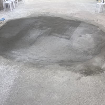 תיקון בטון על משטח חיצוני עם כיסאות פלסטיק ברקע