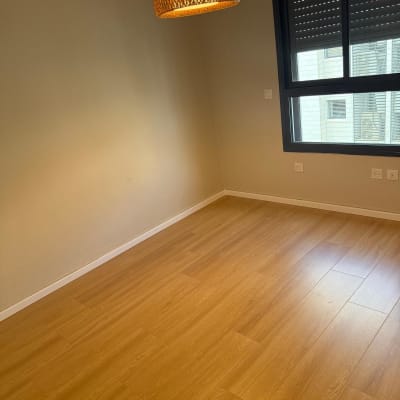 רצפת פרקט עץ בחדר ריק עם קירות בהירים