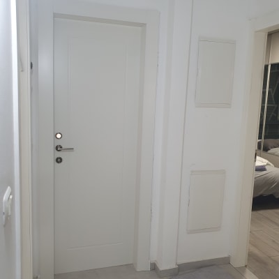 דלת לבנה עם ידית כסופה במסדרון