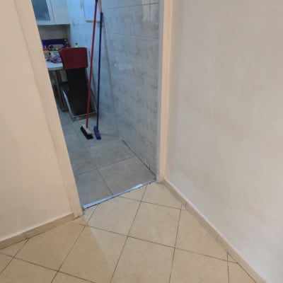 מטאטא ומגב במטבח עם אריחים על הקיר והרצפה