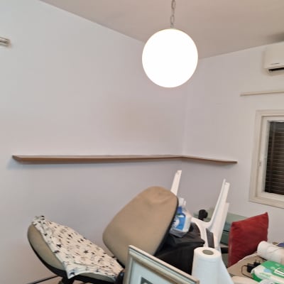 חדר עם קיר צבוע, מדף וכיסאות הפוכים