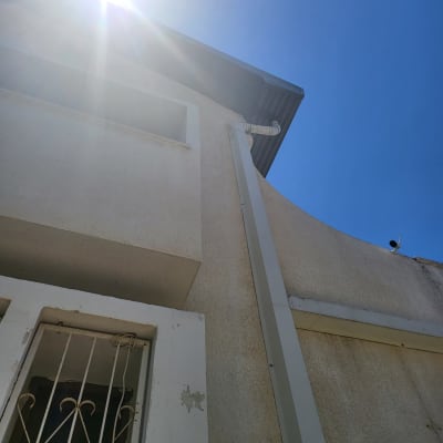 גג עם מרזב מתכת תחת שמש בהירה