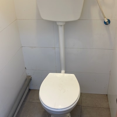 אסלה עם מיכל הדחה וצינור מים