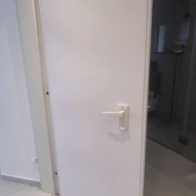 דלת לבנה עם ידית כסופה פתוחה למחצה