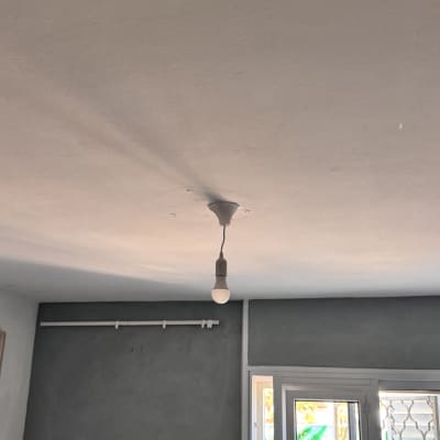 נורה תלויה מהתקרה עם שקעי חשמל על הקיר