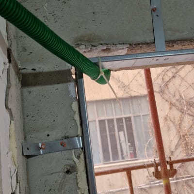 צינור ירוק מותקן על קיר בטון באתר בנייה