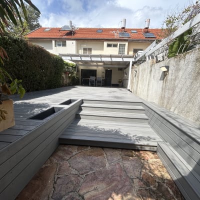 דק עץ בגינה עם מדרגות ועיצוב מודרני