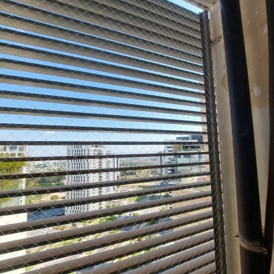 רשת מתכת על חלון למניעת כניסת יונים