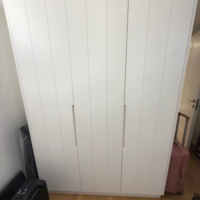 ארון לבן עם מזוודות מסביבו בחדר