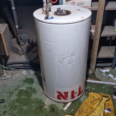 דוד שמש עם צינורות וחיבורים על רצפה ירוקה