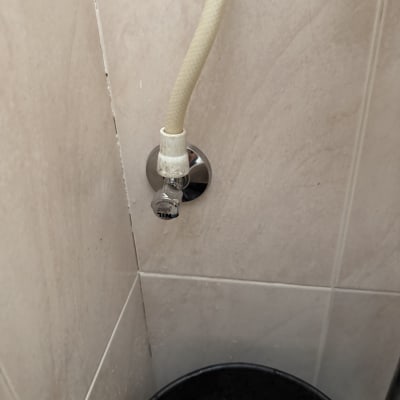 צינור מים מחובר לקיר בחדר אמבטיה