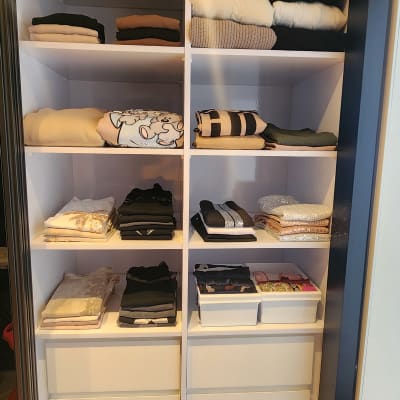 ארון בגדים מסודר עם בגדים מקופלים ומגירות