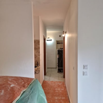 מסדרון עם קירות צבועים ויריעות מגן על הרצפה