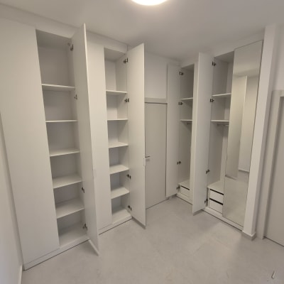 ארונות לבנים עם דלתות פתוחות ומדפים פנימיים