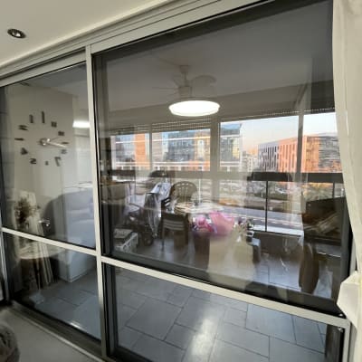 מרפסת עם חלון זכוכית, כיסאות ועציצים