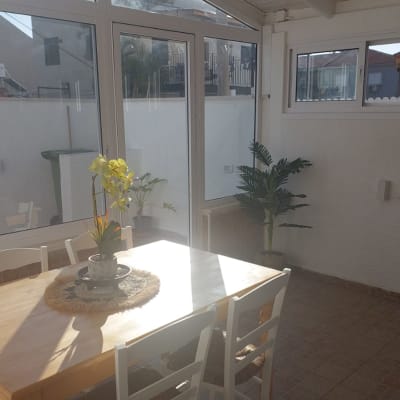 חלונות אלומיניום בחדר שמש עם שולחן וכיסאות