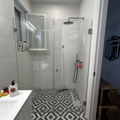 מקלחת עם דלת זכוכית ורצפת אריחים מעוצבת