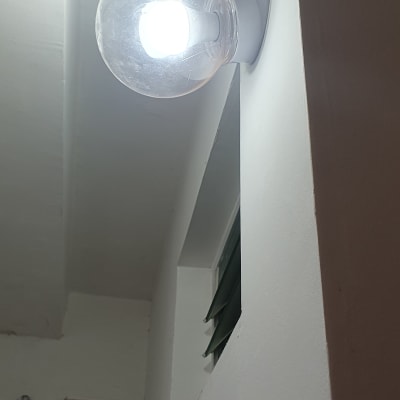 מנורת קיר עגולה עם נורה דולקת