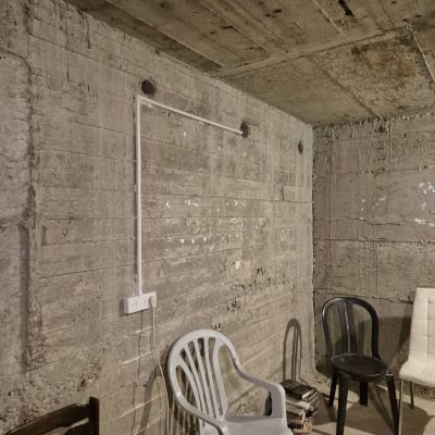 שקע חשמל מותקן על קיר בטון עם כיסאות פלסטיק סביב