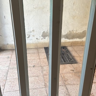 חלון זכוכית עם מסגרת מתכת על רצפת אריחים