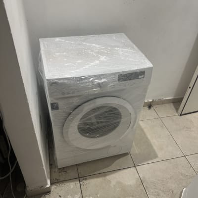 מכונת כביסה עטופה בניילון בחדר ריק