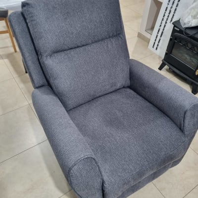 כורסה מרופדת בצבע אפור בחדר מגורים