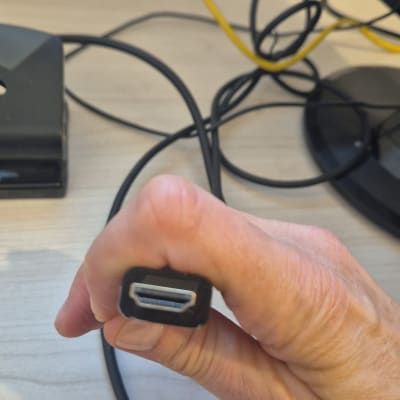 מחבר HDMI מוחזק ביד על רקע שולחן