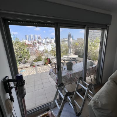 תריסים סגורים על חלון זכוכית גדול במרפסת