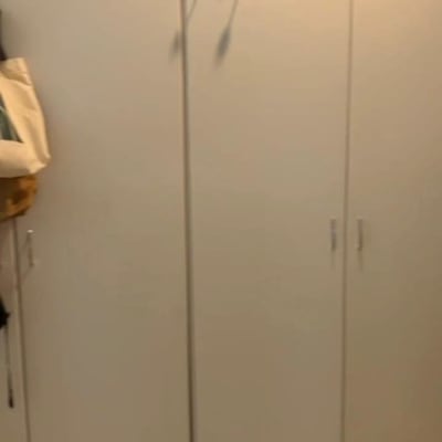 ארון לבן עם ידיות מתכת בחדר